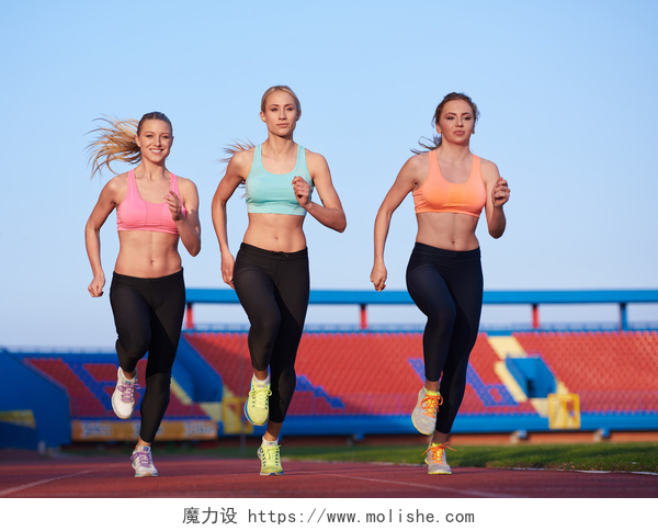 三个女孩在操场跑步在田径比赛跑道上运行的运动员妇女组